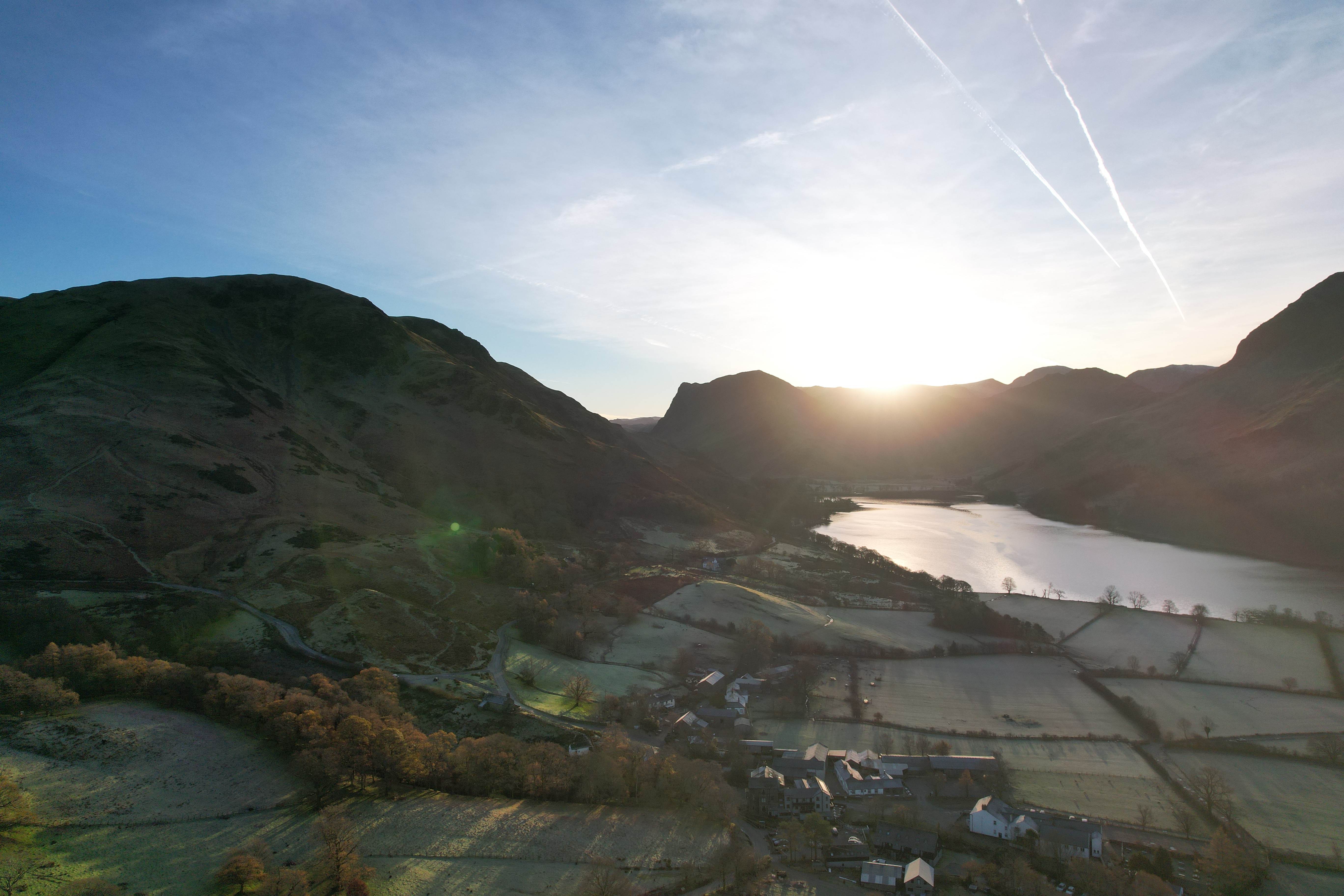 Drone view of Scottish loch at sunrise with mountains and valley