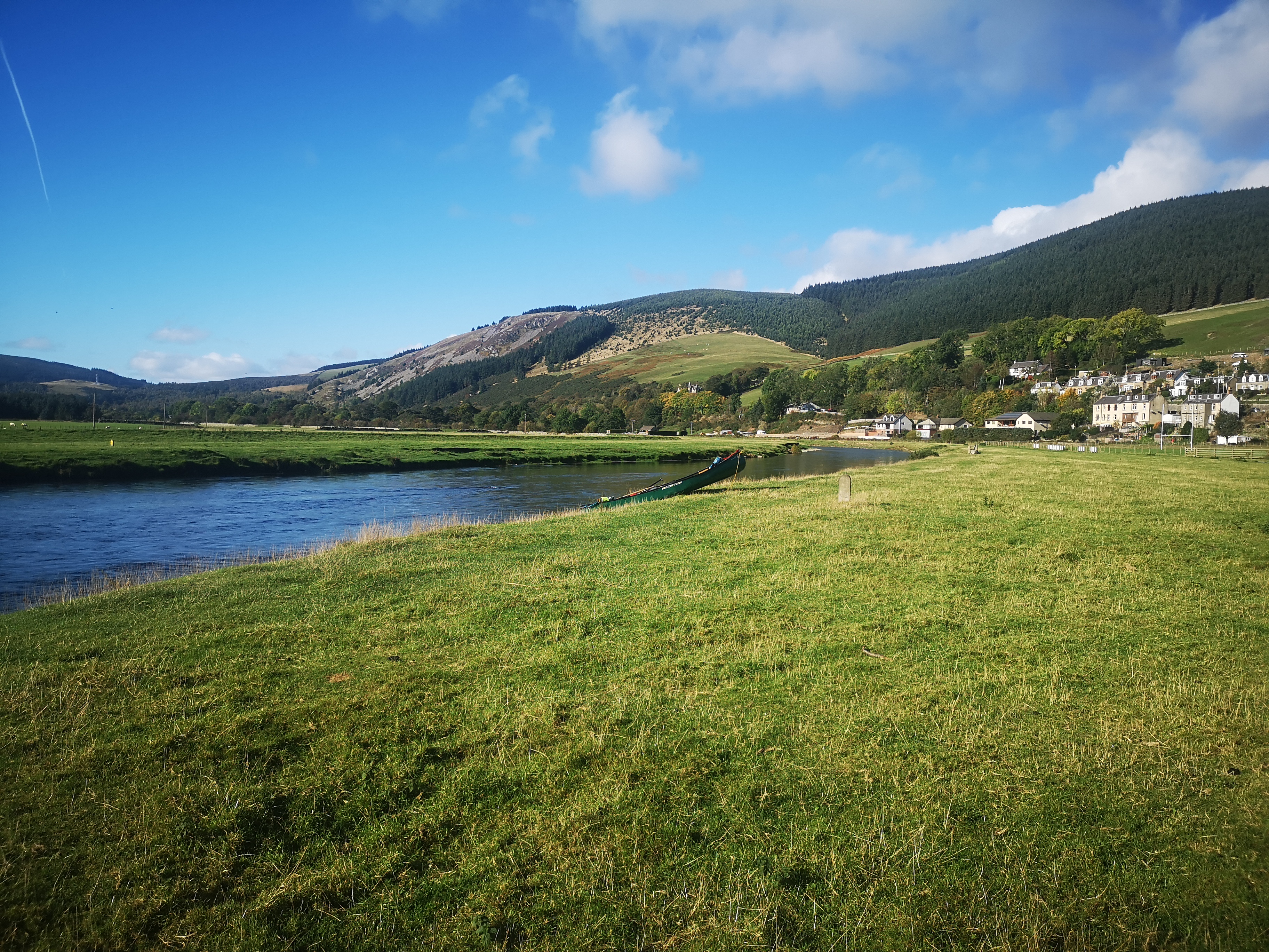 River Tweed flowing past Scottish village with forested mountains
