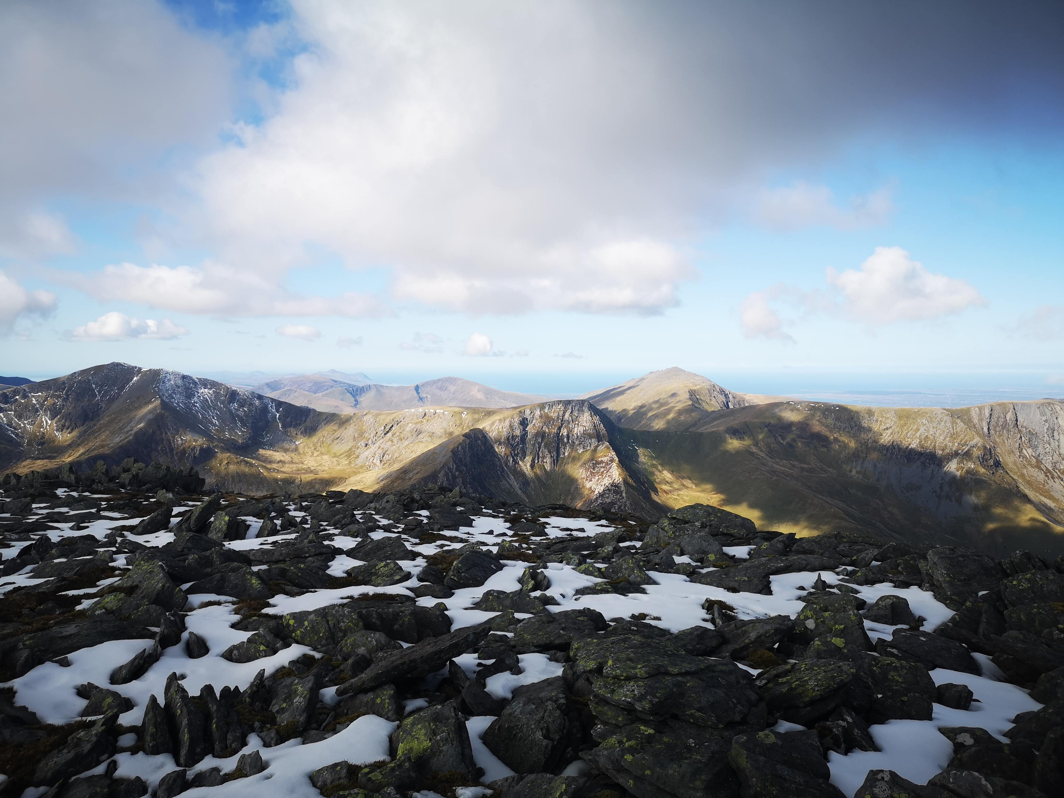 Snow-capped mountain peaks panorama with patches of winter snow