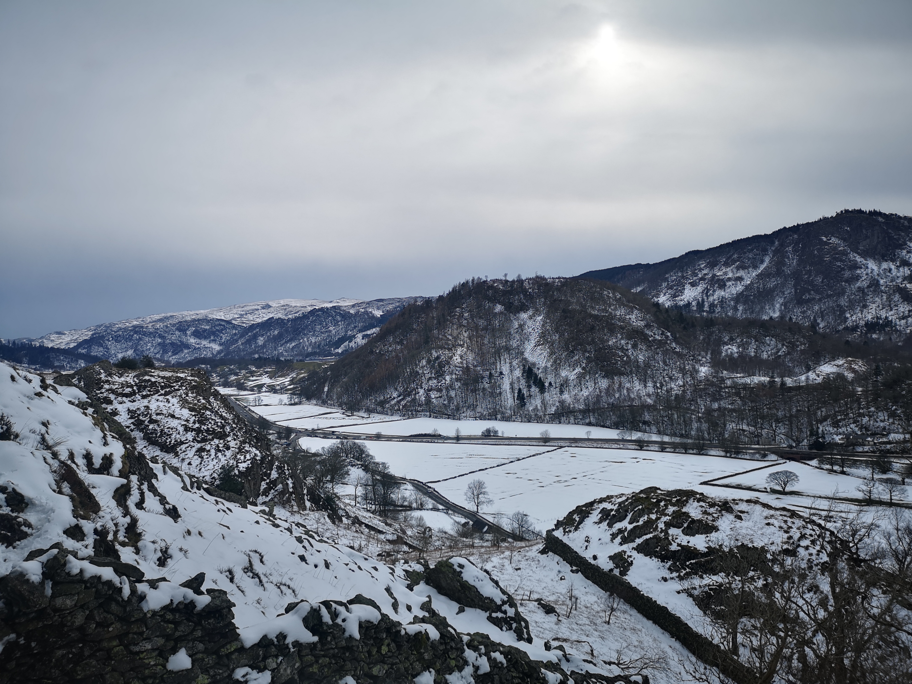 Snow-covered Scottish valley with frozen fields and mountains